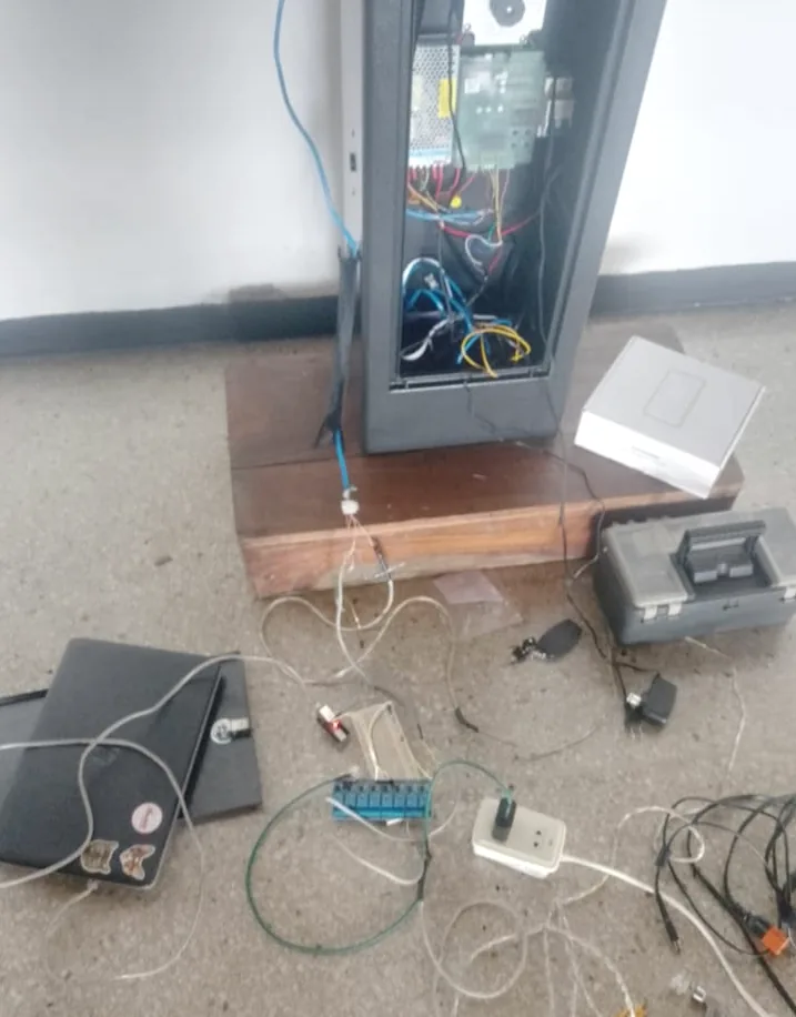 Torniquete peatonal con su gabinete abierto y herramientas en el piso durante el cableado.